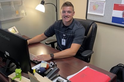 Mason Dishong sits behind desk as he interns for Holzer Health Systems