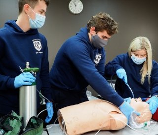 Students performing CPR on mannequin