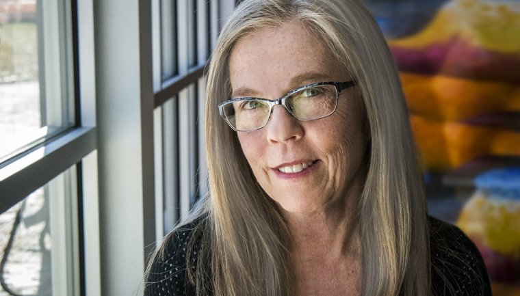 Poet Laureat Kari Gunter-Semour is picture beside window.