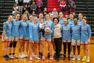 Pictured is athlete Lexi woods, her son Zakai, and the women's basketball team.