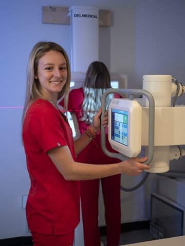 Radiological student smiles at the camera as she prepares to give an xray 